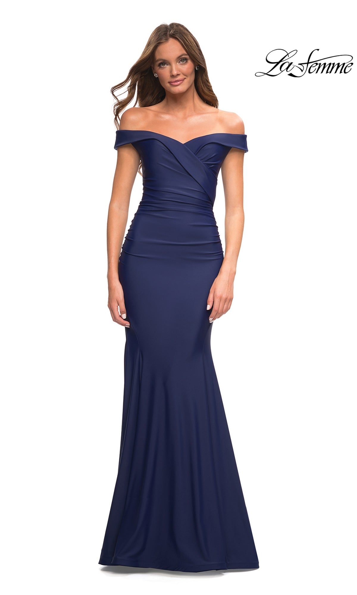 A woman wears a navy blue La Femme Off-the-Shoulder Long Formal Prom Gown with a fitted bodice and subtle mermaid silhouette. The La Femme logo appears in the top right corner.